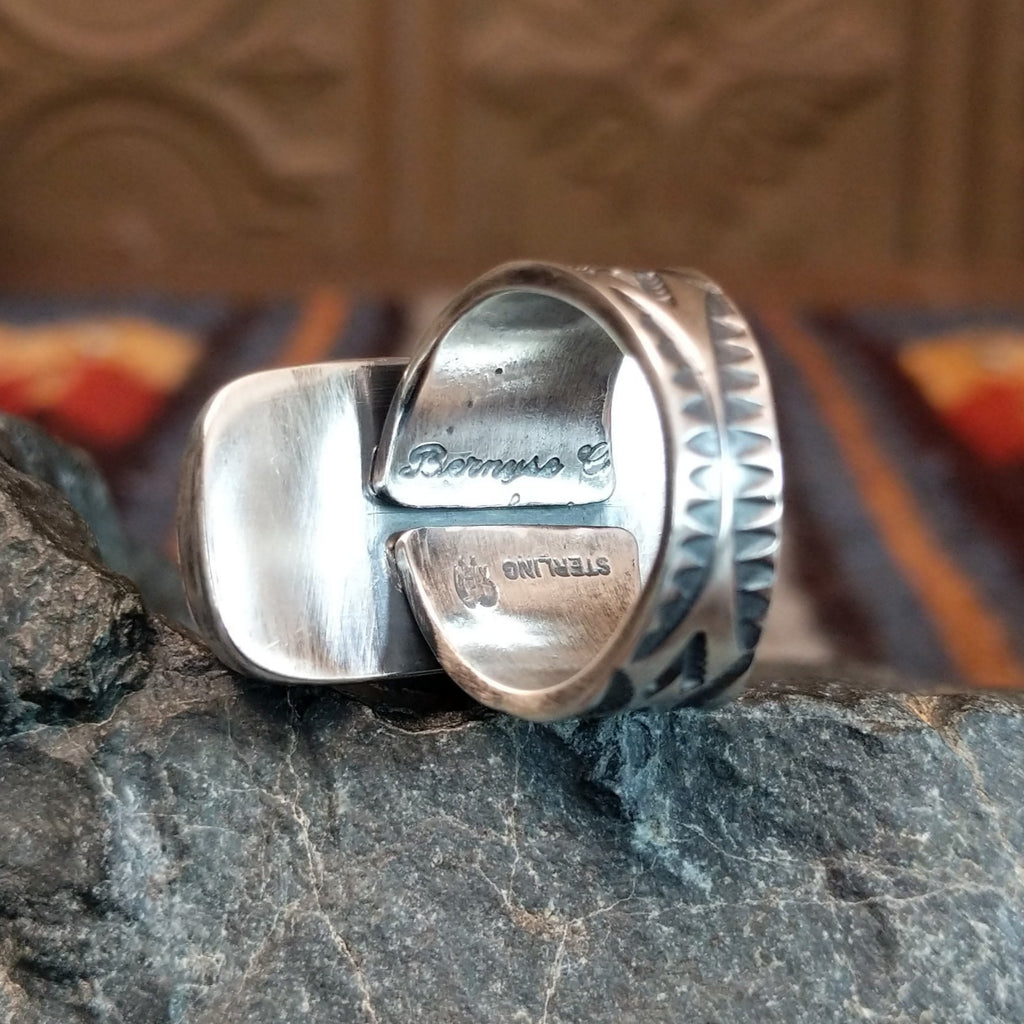 The artist's signature and stamp is found on the underside of the band.