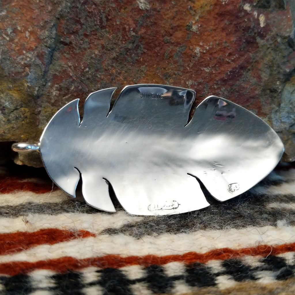 The back features the artisan's signature.