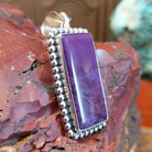 Sterling silver pendant with rectangular sugilite framed by dotted accents.