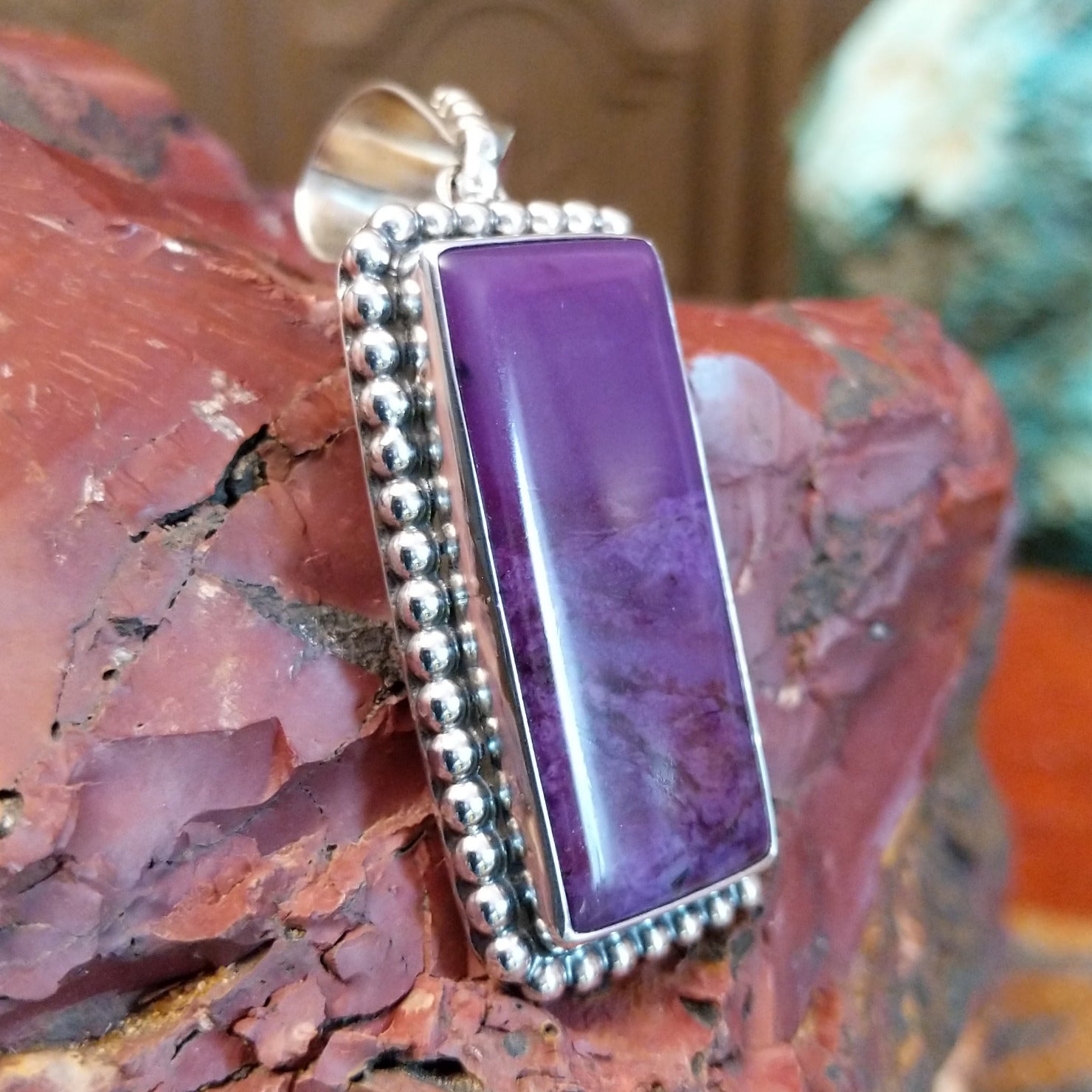 Sterling silver pendant with rectangular sugilite framed by dotted accents.