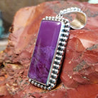 Sterling silver pendant with rectangular sugilite framed by dotted accents.
