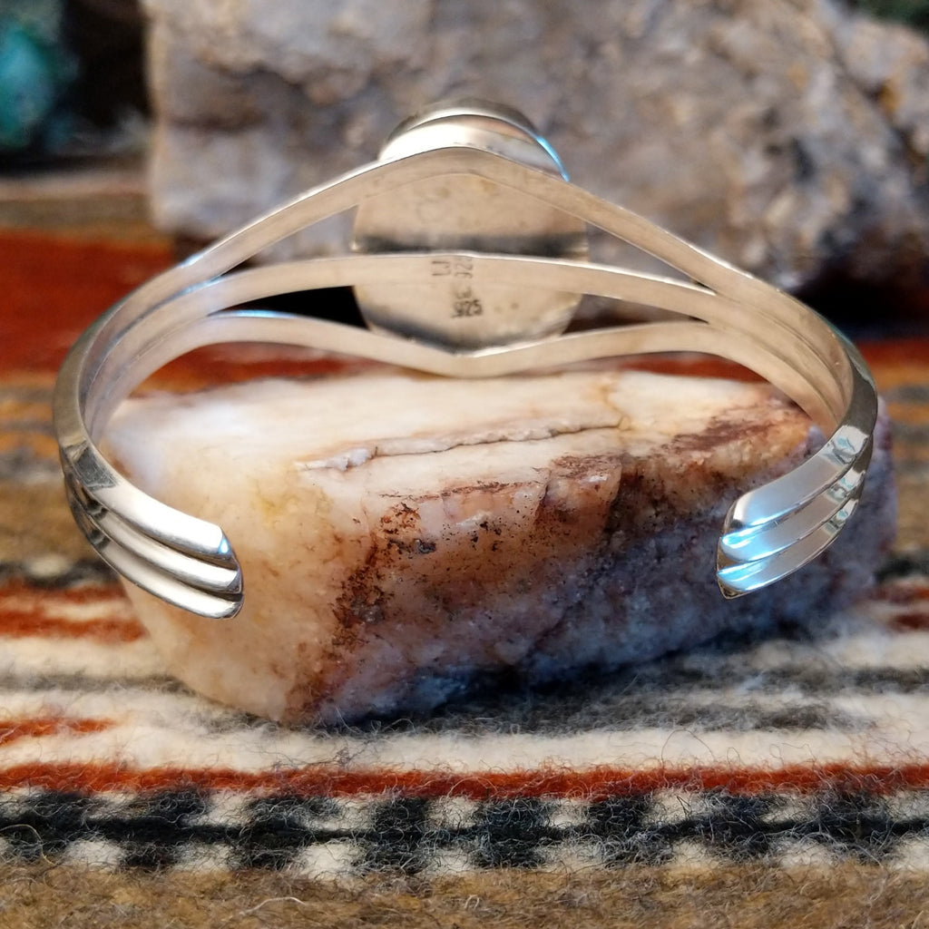 Polished sterling silver band of the cuff.