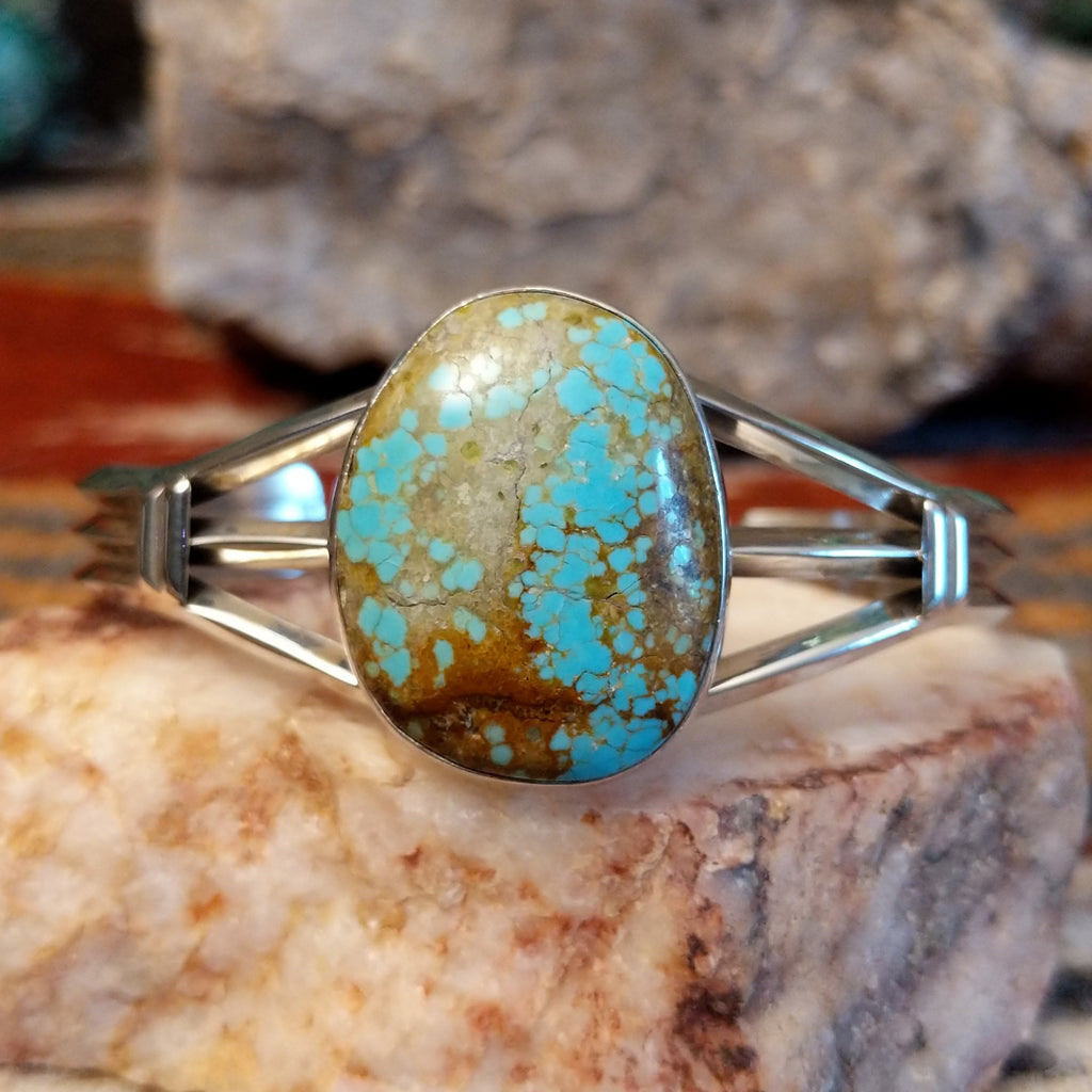 Sterling silver cuff with a large turquoise stone set in the bezel.