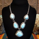 Sterling silver necklace with larimar set in geometric bezels, framed by twisted rope and stamped accents.