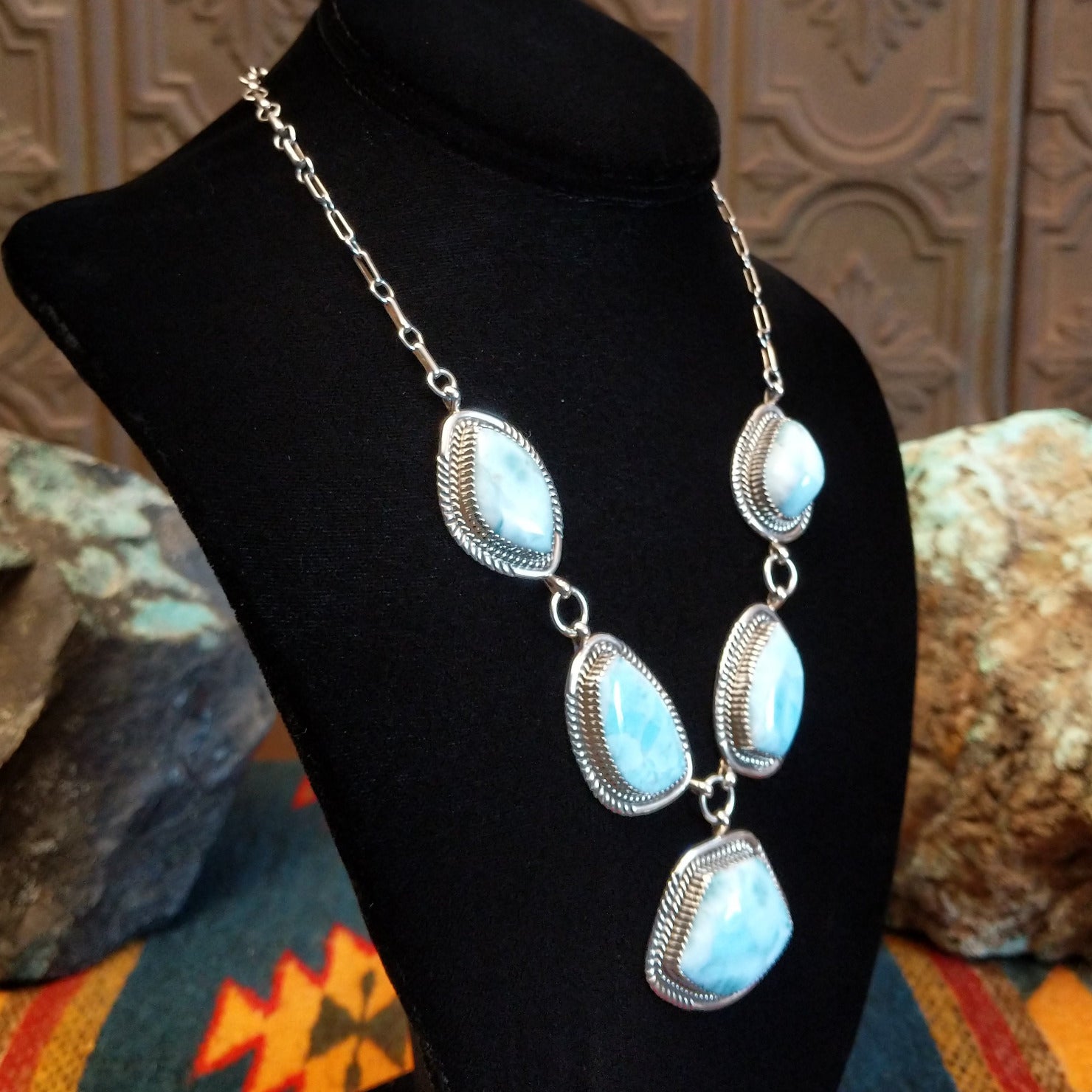 Sterling silver necklace with larimar set in geometric bezels, framed by twisted rope and stamped accents.