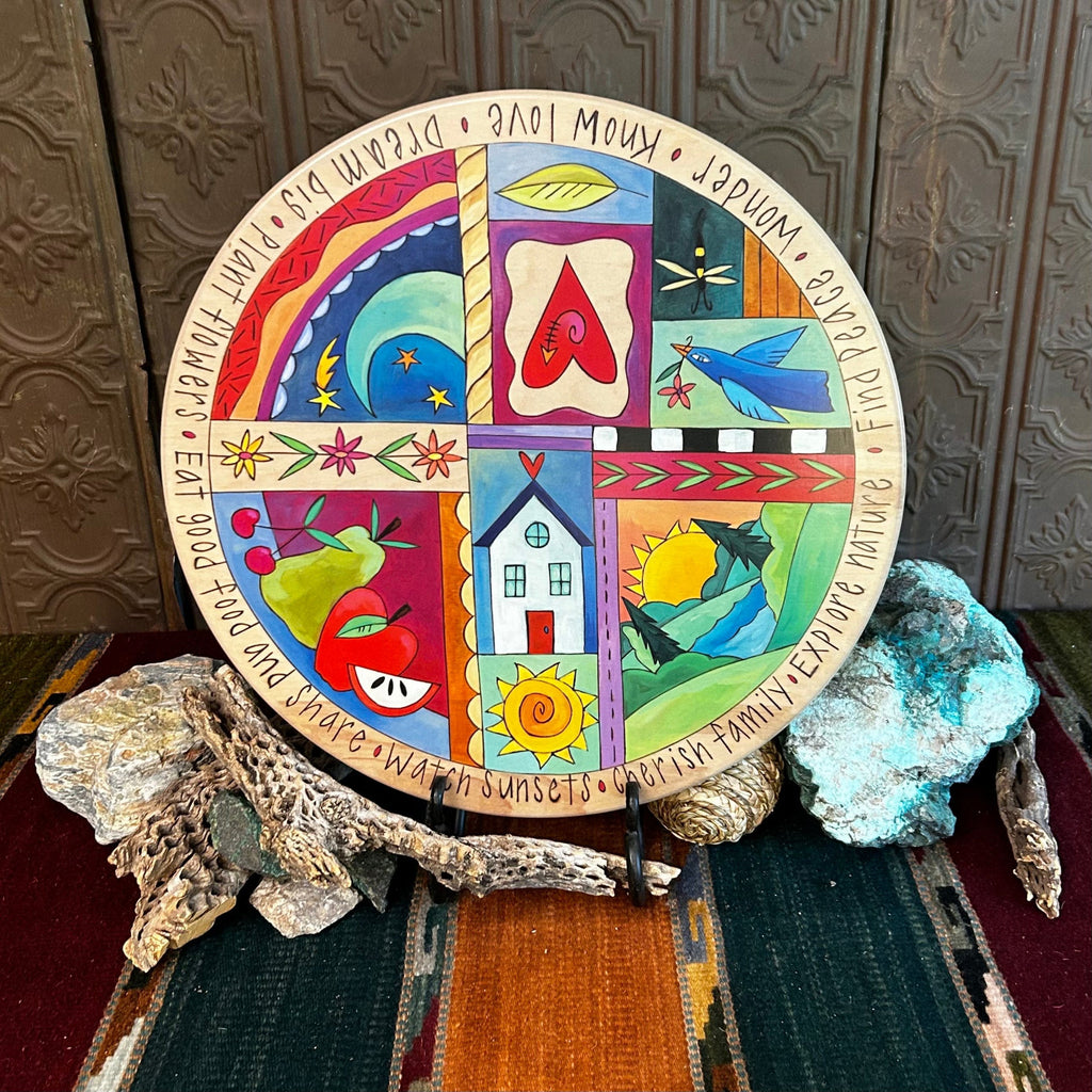 Wooden lazy susan with decorative designs such as birds, apples, and various motifs in vibrant colors.