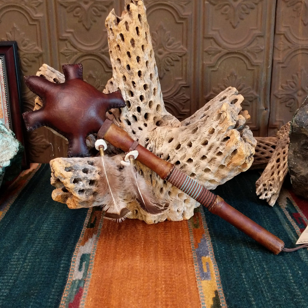 Leather turtle dance rattle with feather accents, beads, and antler shaft.