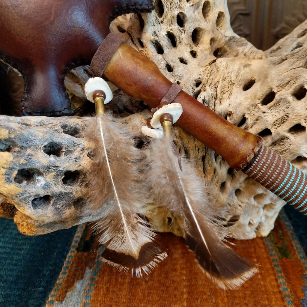 Close-up of the two feathers attached to the shaft of the piece.