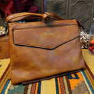 Lexi Crossbody Bag by Liz Soto featuring a streamlined silhouette, textured exterior, envelope-style front pocket, adjustable shoulder strap, metal hardware, and Liz Soto logo.