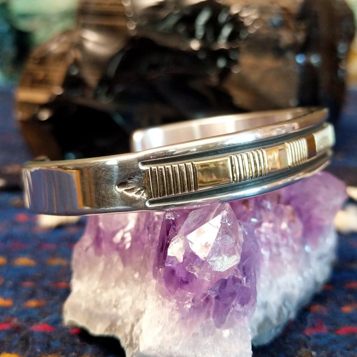 Polished sterling silver and gold cuff featuring intricate line-work.