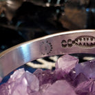The artist's signature and authentication stamps are found on the inner side of the band.