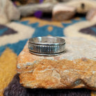 Sterling silver band ring by Bruce Morgan with hand-stamped linear detailing.