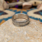 Sterling silver band ring by Bruce Morgan with hand-stamped linear detailing.