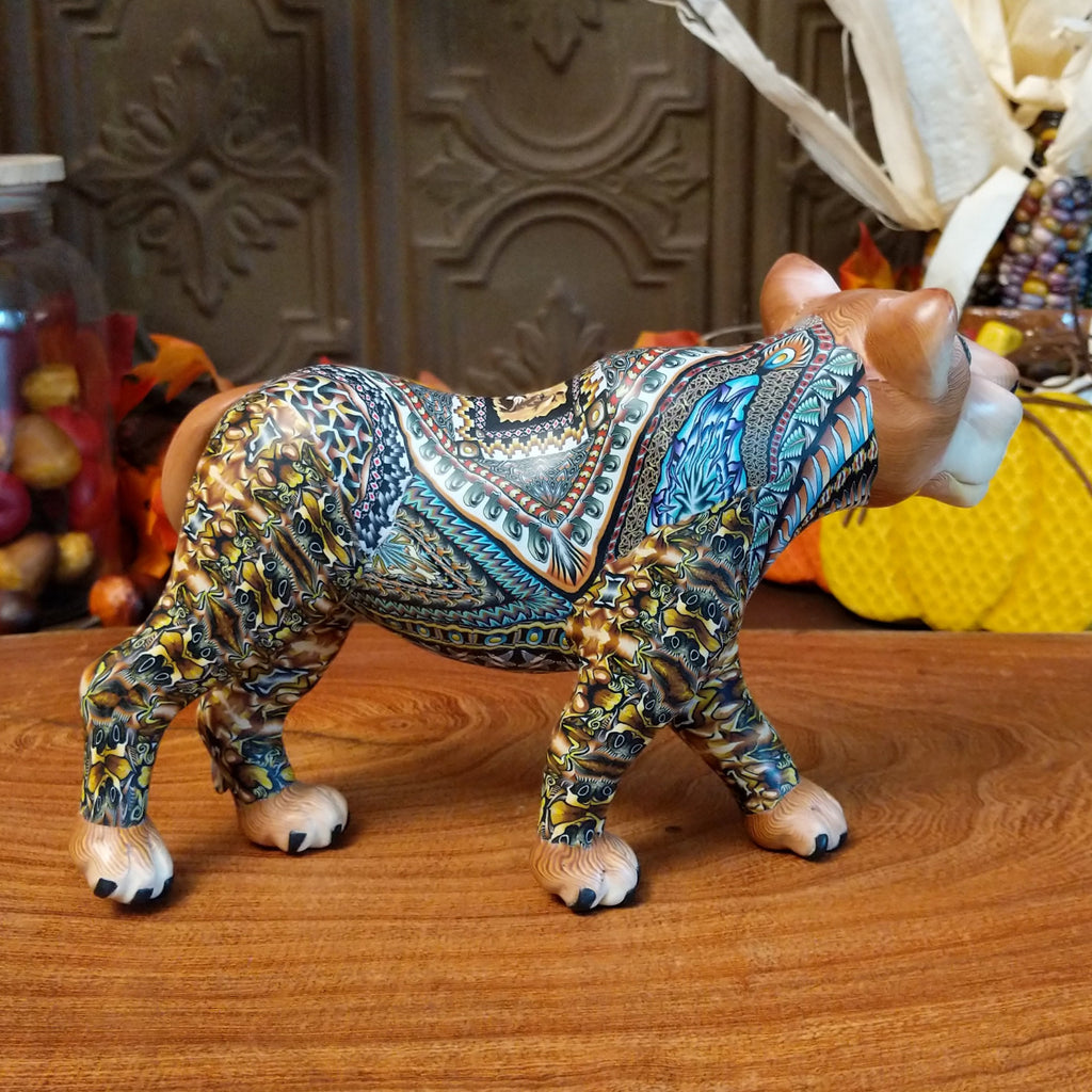 Polymer clay lioness with detailed face and vibrant designs all along the body.