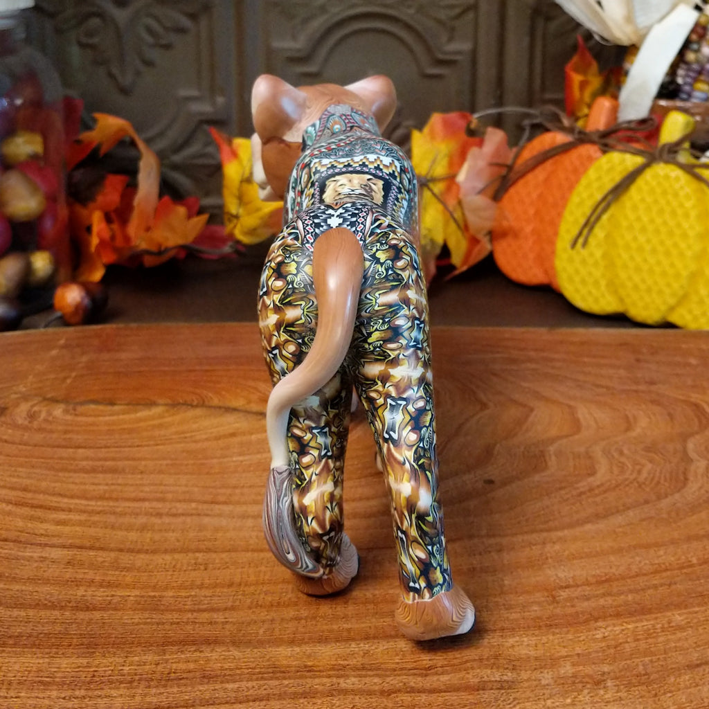 Polymer clay lioness with detailed face and vibrant designs all along the body.