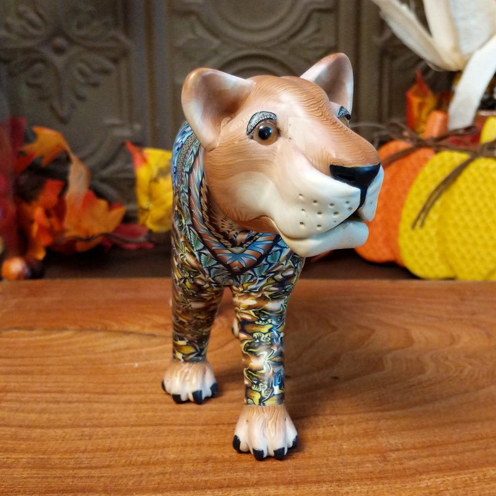 Polymer clay lioness with detailed face and vibrant designs all along the body.