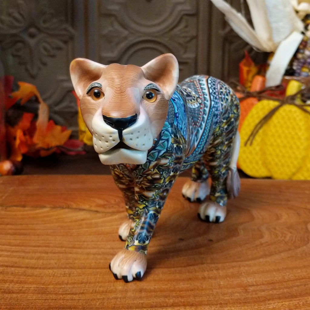 Polymer clay lioness with detailed face and vibrant designs all along the body.