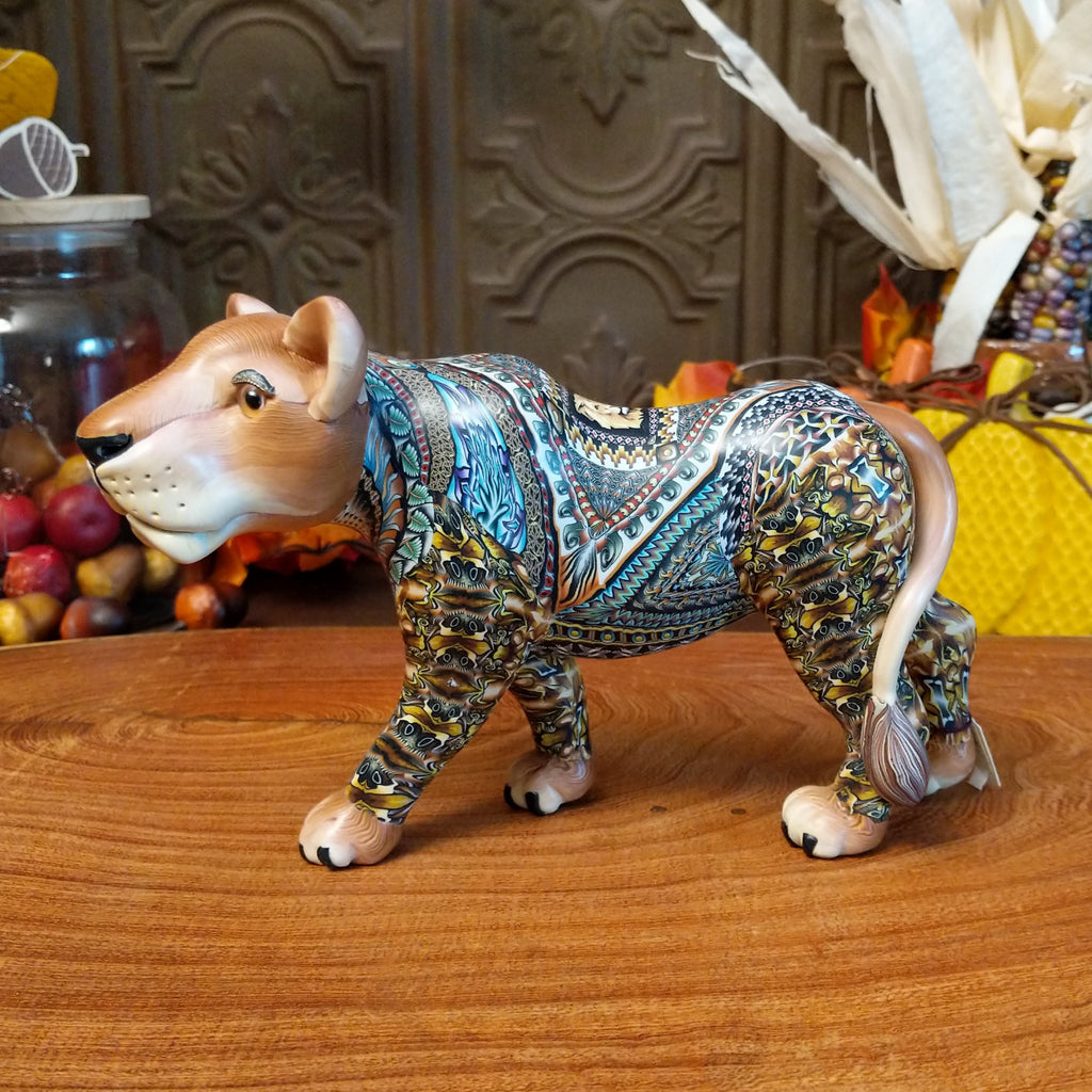 Polymer clay lioness with detailed face and vibrant designs all along the body.