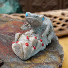Lizard and prickly pear Zuni fetish carving by Alvin Haloo with turquoise inlaid eyes and red prickly pear fruit accents.