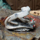 Lizard and prickly pear Zuni fetish carving by Alvin Haloo with turquoise inlaid eyes and red prickly pear fruit accents.
