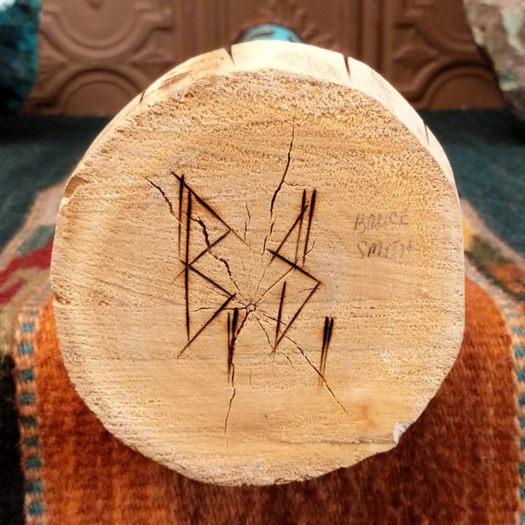 The base features the artisan's signature.