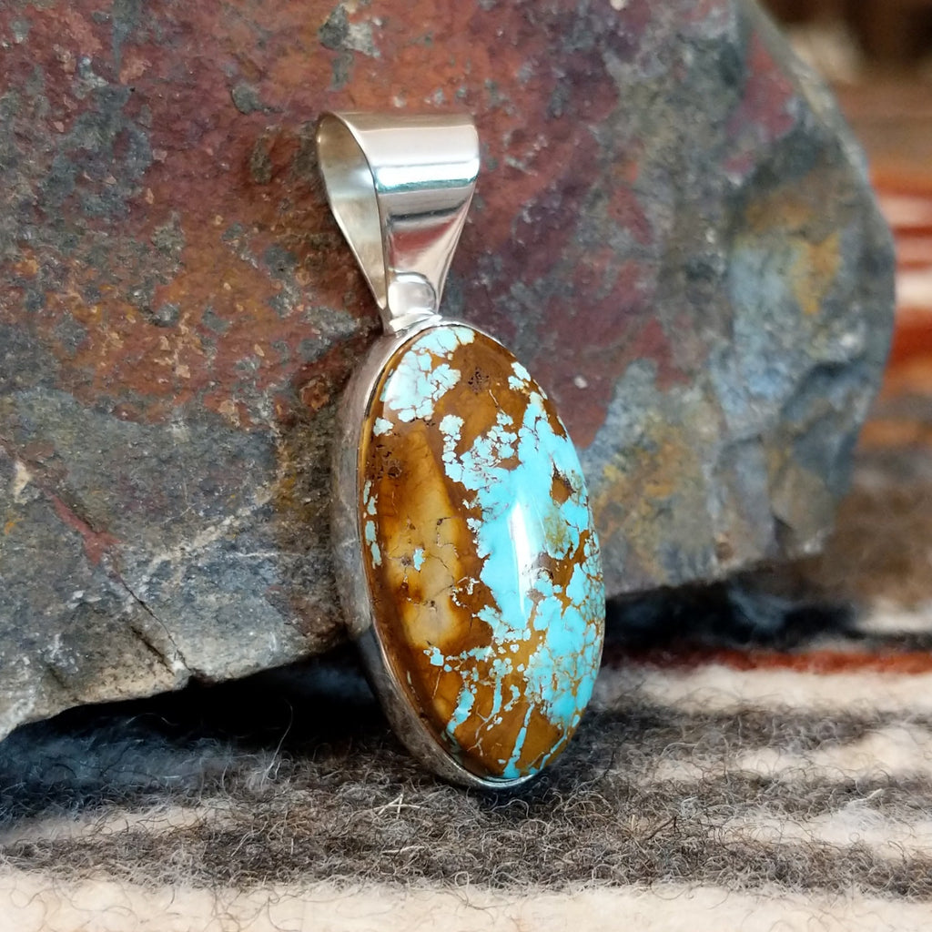 Oval sterling silver pendant with boulder turquoise set in the bezel.