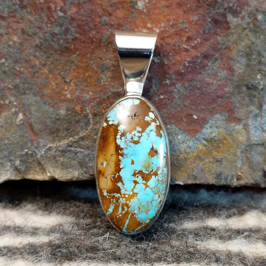 Oval sterling silver pendant with boulder turquoise set in the bezel.