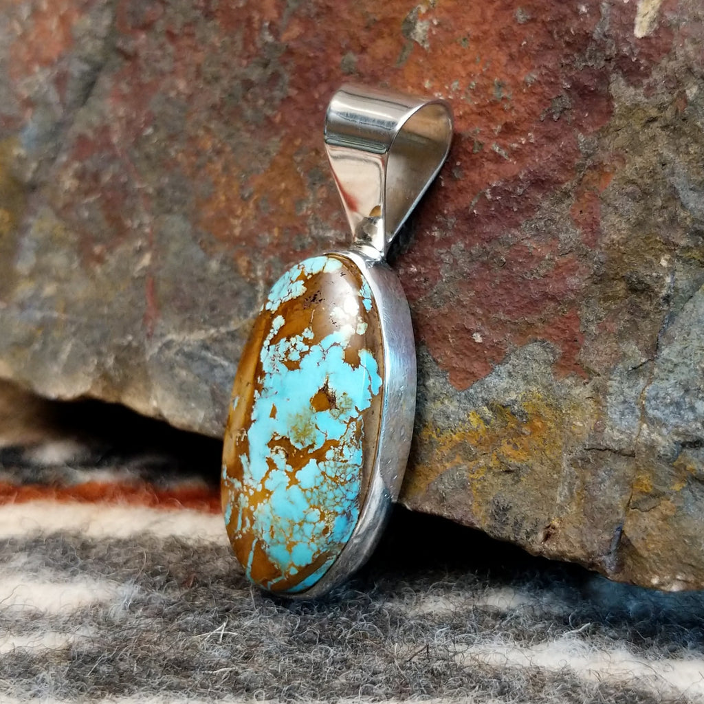 Oval sterling silver pendant with boulder turquoise set in the bezel.