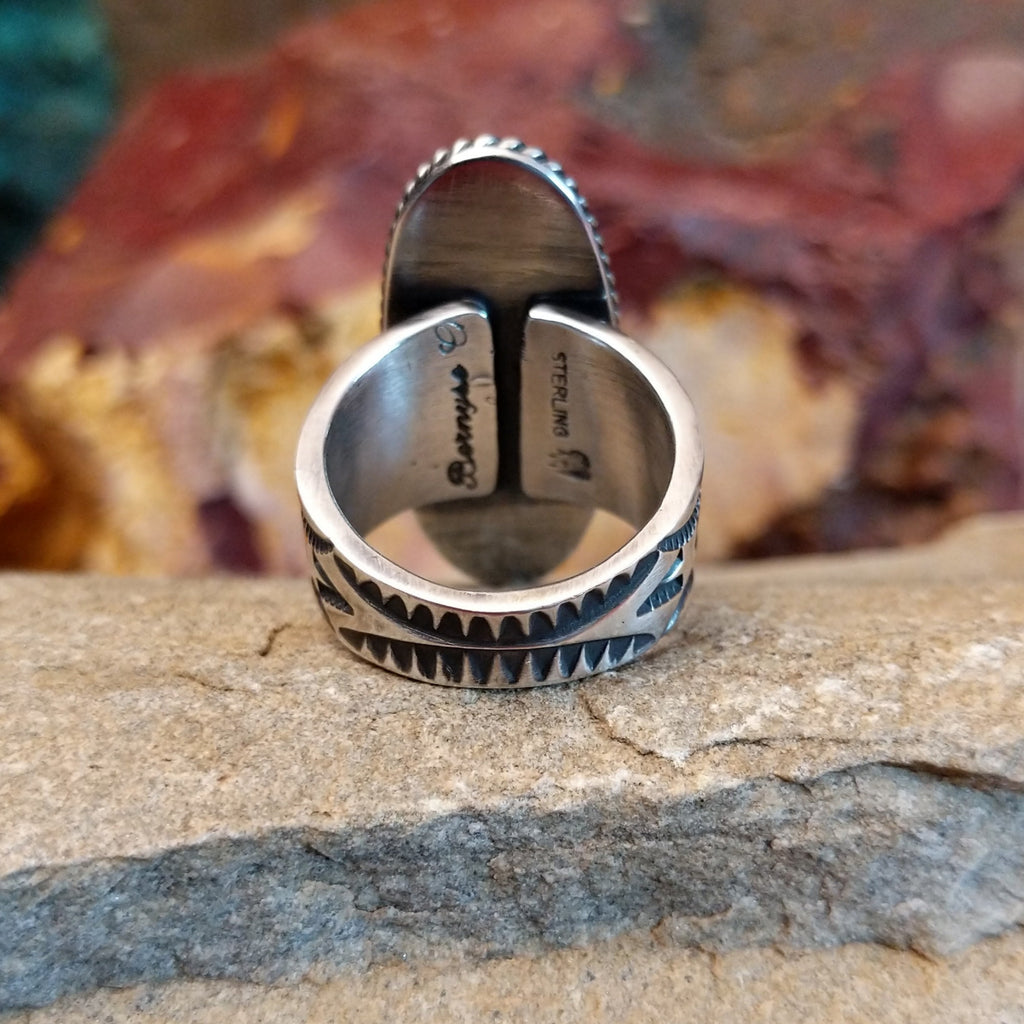 The band of the ring is intricately stamped with various designs.