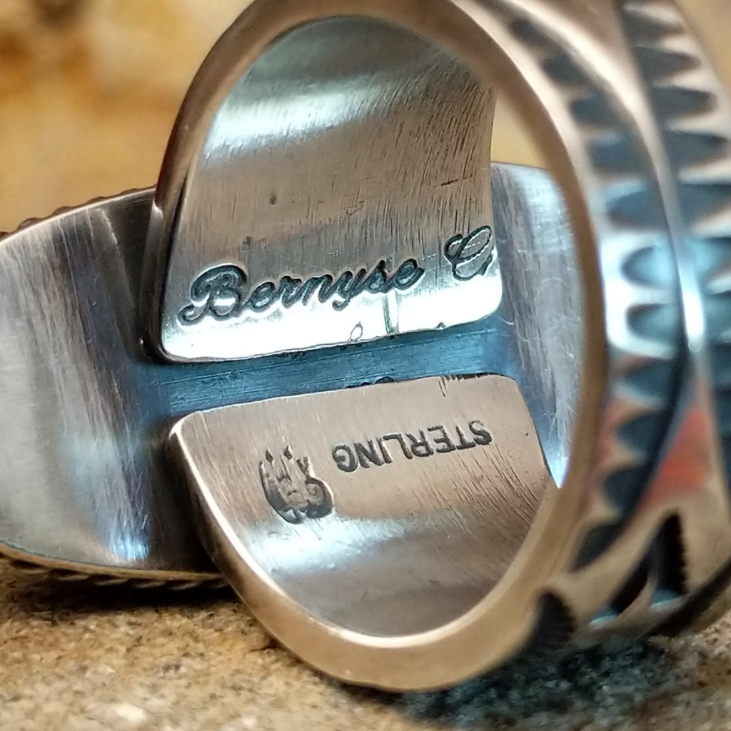The artisan's signature is stamped on the underside of the band.