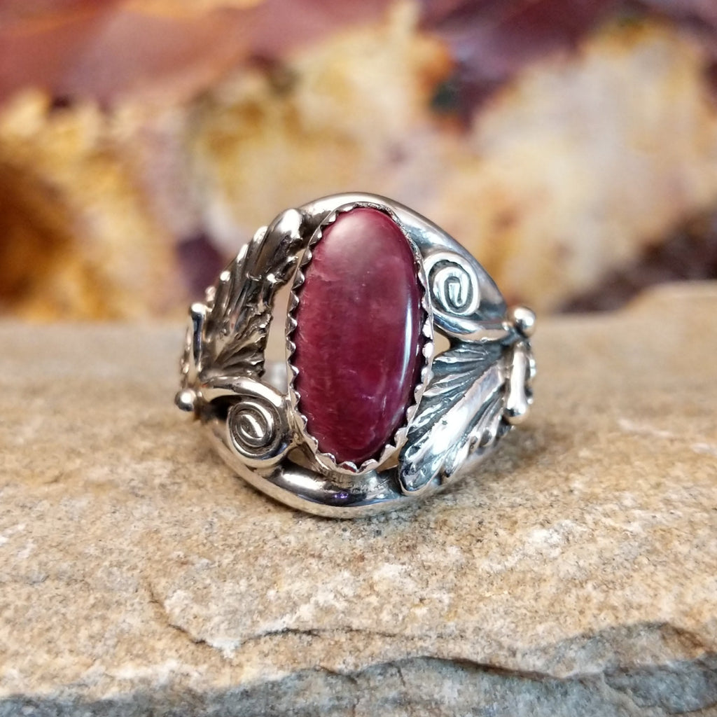 Intricate sterling silver motifs with a long oval purple spiny oyster stone set in a notched bezel.