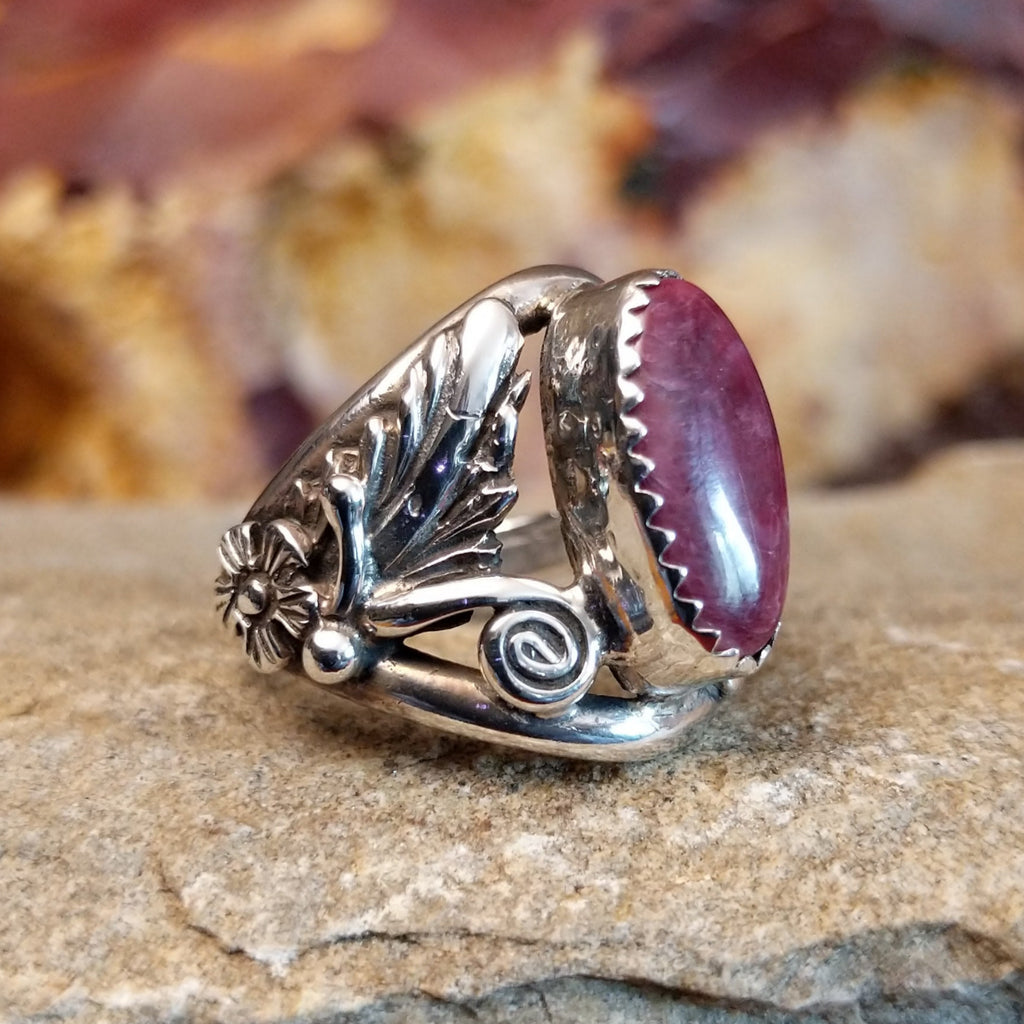 Intricate sterling silver motifs with a long oval purple spiny oyster stone set in a notched bezel.