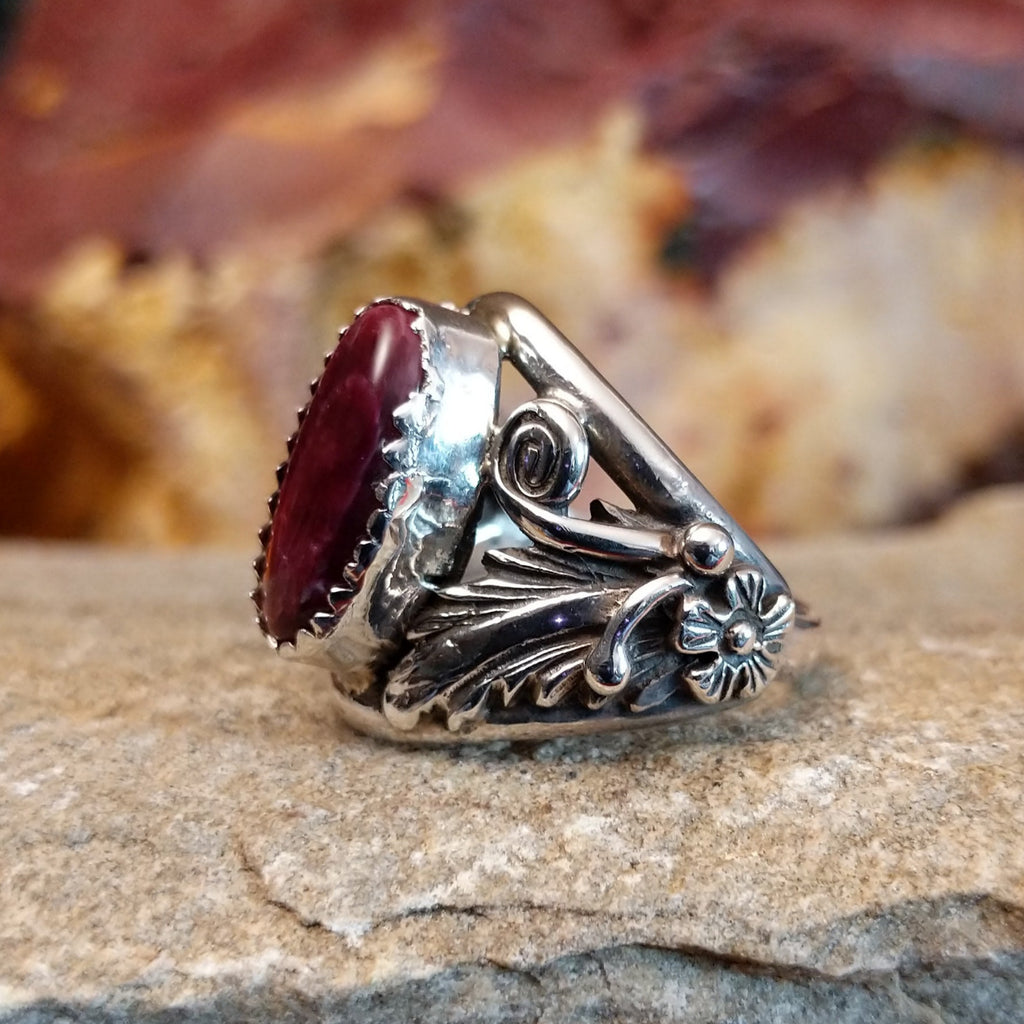 Intricate sterling silver motifs with a long oval purple spiny oyster stone set in a notched bezel.