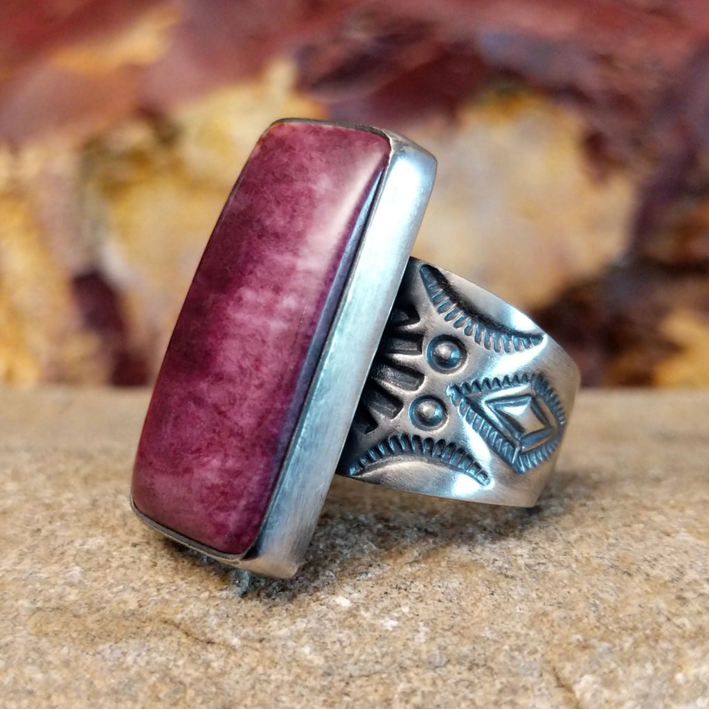 Long rectangular purple spiny oyster shell set in a smooth bezel with an intricately stamped band.