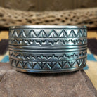 Longhorn stamped sterling silver cuff by E. Piaso, featuring bold geometric hand-stamped longhorn-inspired patterns on a handcrafted wide sterling silver open cuff.