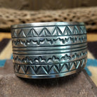 Longhorn stamped sterling silver cuff by E. Piaso, featuring bold geometric hand-stamped longhorn-inspired patterns on a handcrafted wide sterling silver open cuff.