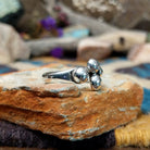 Handcrafted Navajo sterling silver ring by Leon Martinez featuring four graduated polished silver domes in a modern open-loop design with a high-polish finish; side view.