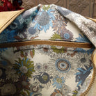 Lulu Handbag by Liz Soto featuring a spacious hobo silhouette, soft suede-like exterior, long shoulder strap, side buckle detailing, top zip closure, and logo plaque; interior.