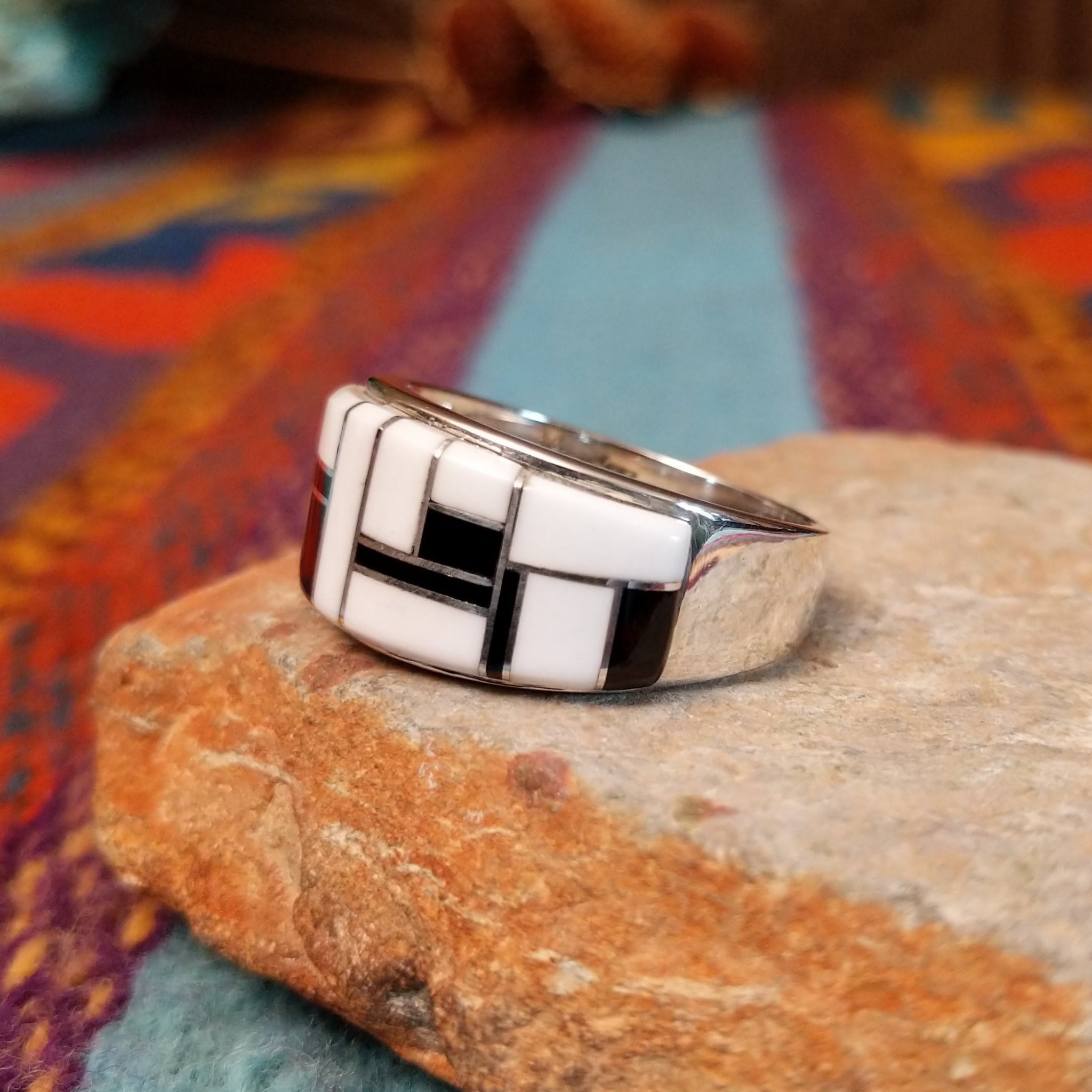 Magnesite & Black Onyx Ring by Karen Skeet featuring geometric white magnesite and black onyx inlay separated by fine silver channels across a wide polished silver band; side view.