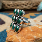 Handcrafted sterling silver malachite cluster ring by Gilo & Grace Nakai, featuring nine oval malachite gemstones with natural green banding; side view.