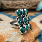 Handcrafted sterling silver malachite cluster ring by Gilo & Grace Nakai, featuring nine oval malachite gemstones with natural green banding; side view.