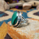 Sterling silver Malachite ring by Terry Wood featuring an oval green stone with natural banding; side view.