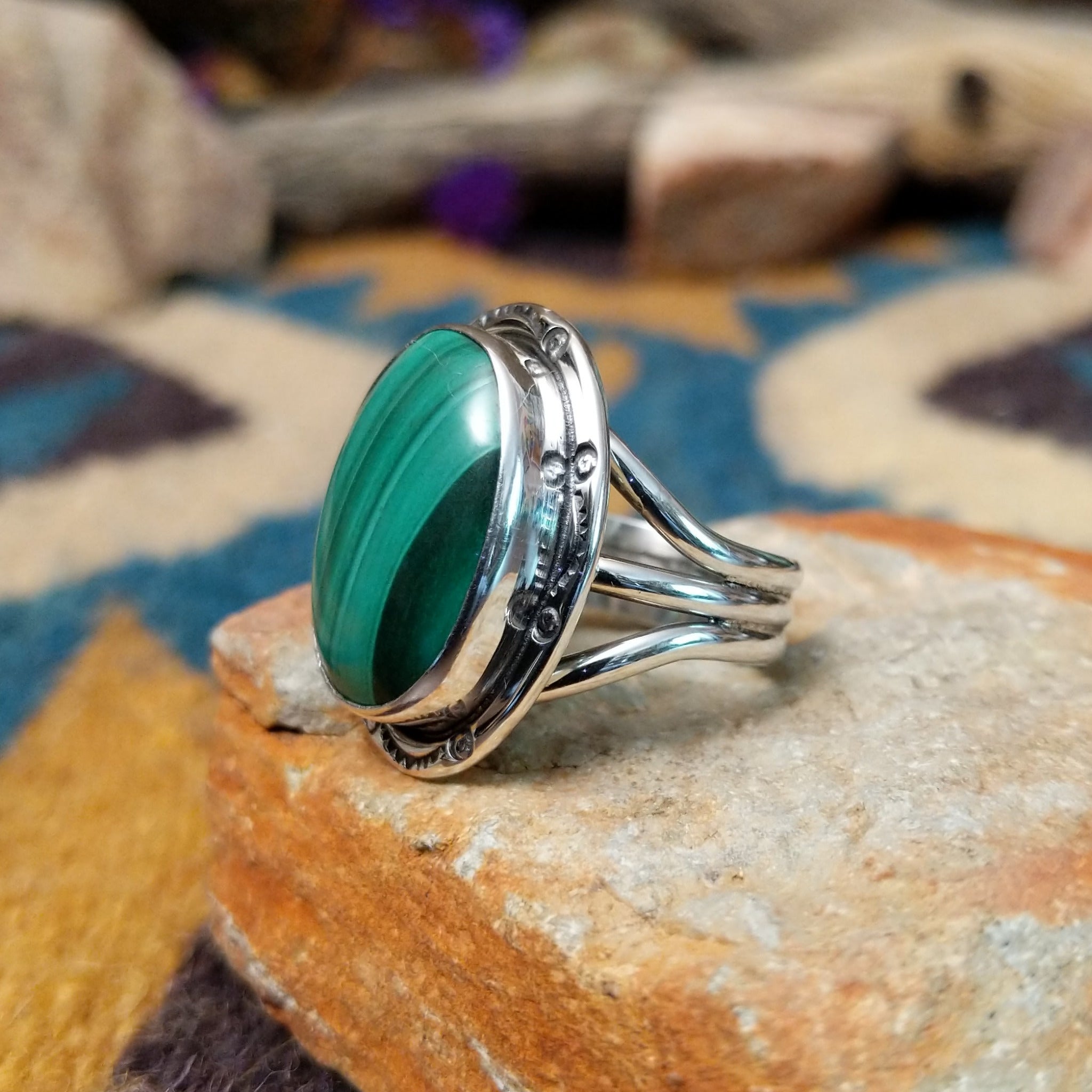 Sterling silver Malachite ring by Terry Wood featuring an oval green stone with natural banding; side view.