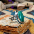 Sterling silver Malachite ring by Terry Wood featuring an oval green stone with natural banding; side view.