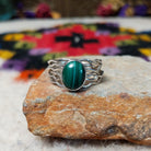 Graceful Malachite Ring by Angela Martin featuring an oval green banded malachite stone set in sterling silver with flowing wave-like silver strands.