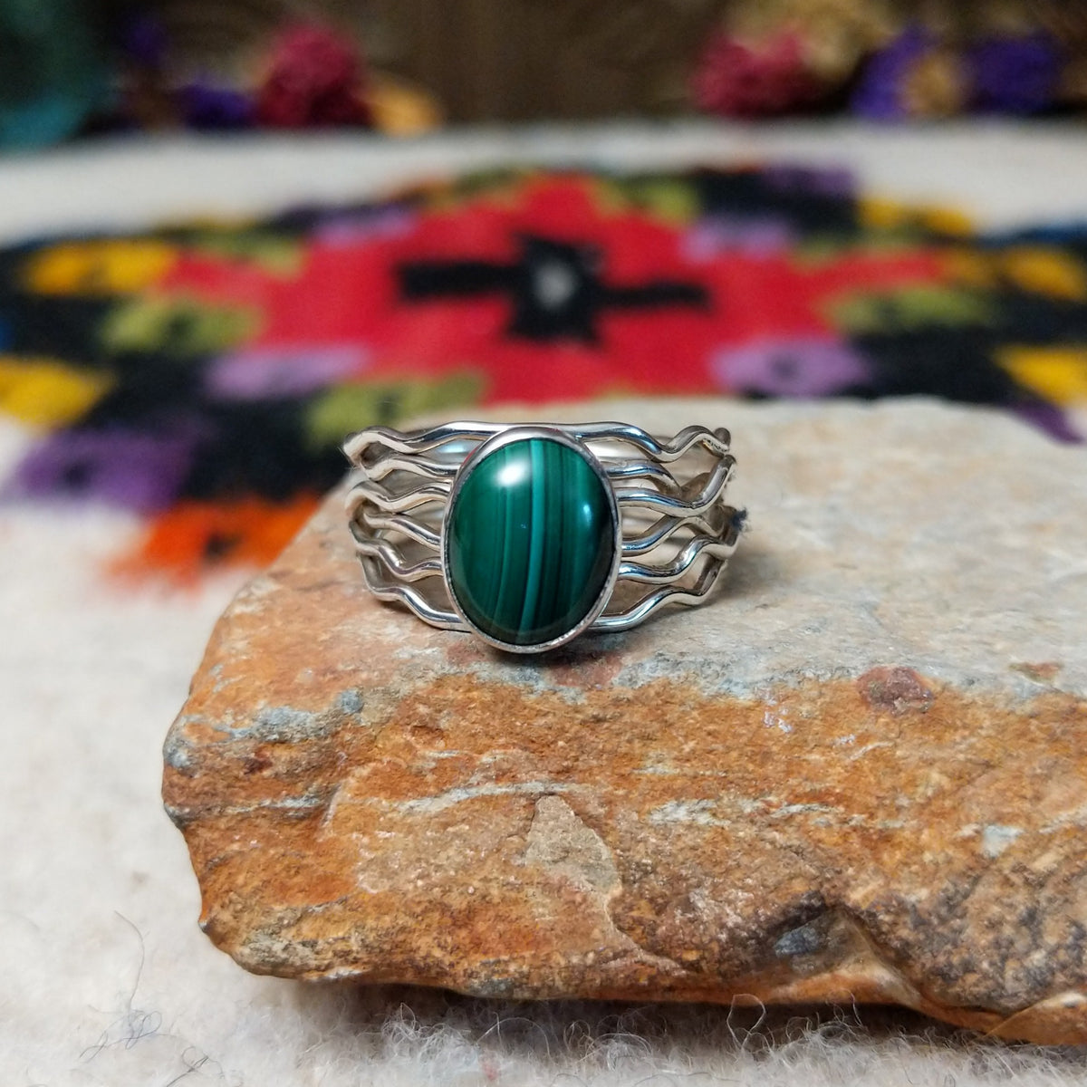Graceful Malachite Ring by Angela Martin featuring an oval green banded malachite stone set in sterling silver with flowing wave-like silver strands.