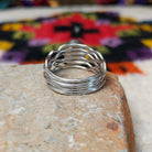 Graceful Malachite Ring by Angela Martin featuring an oval green banded malachite stone set in sterling silver with flowing wave-like silver strands; underside view.