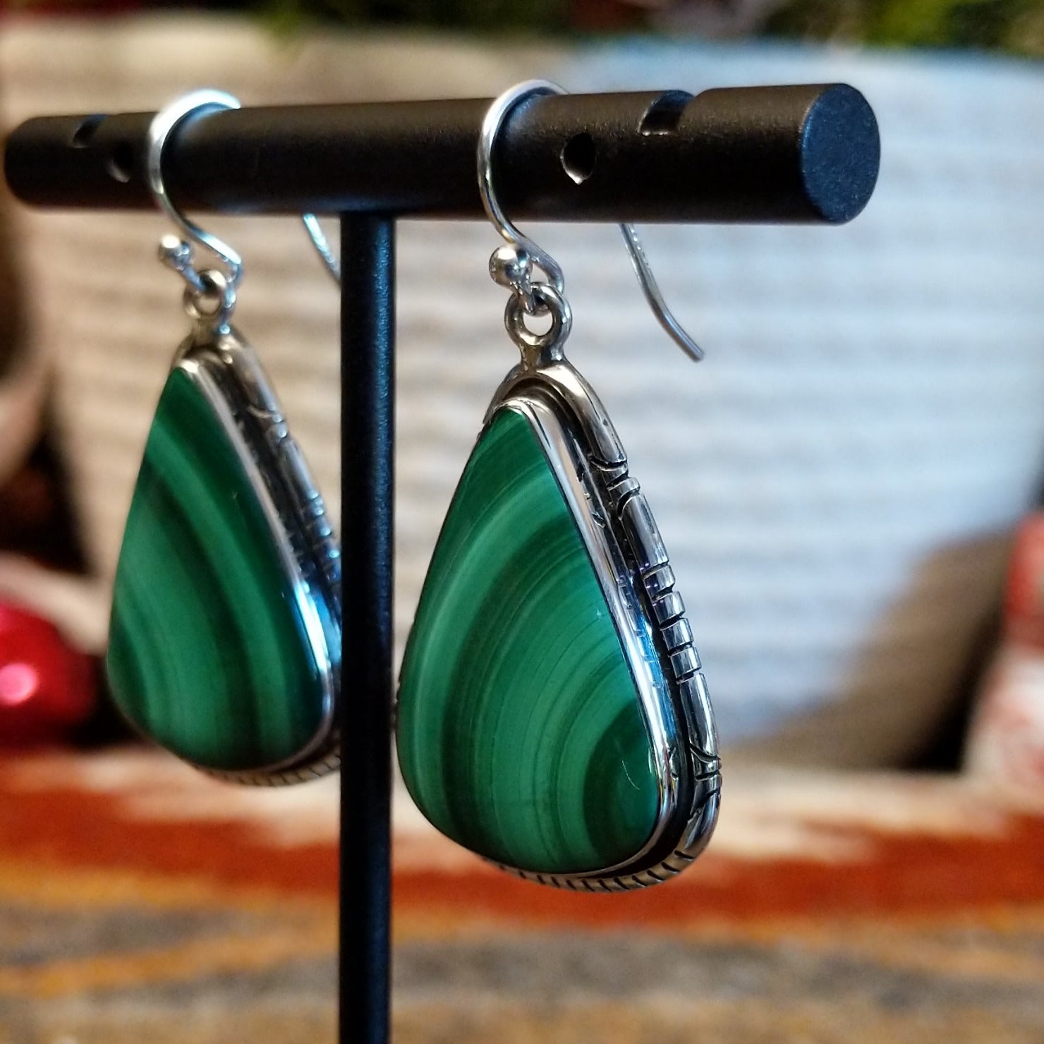 Triangular sterling silver malachite earrings framed by a stamped bezel.