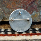 The back of the pendant features the artisan's hallmark.