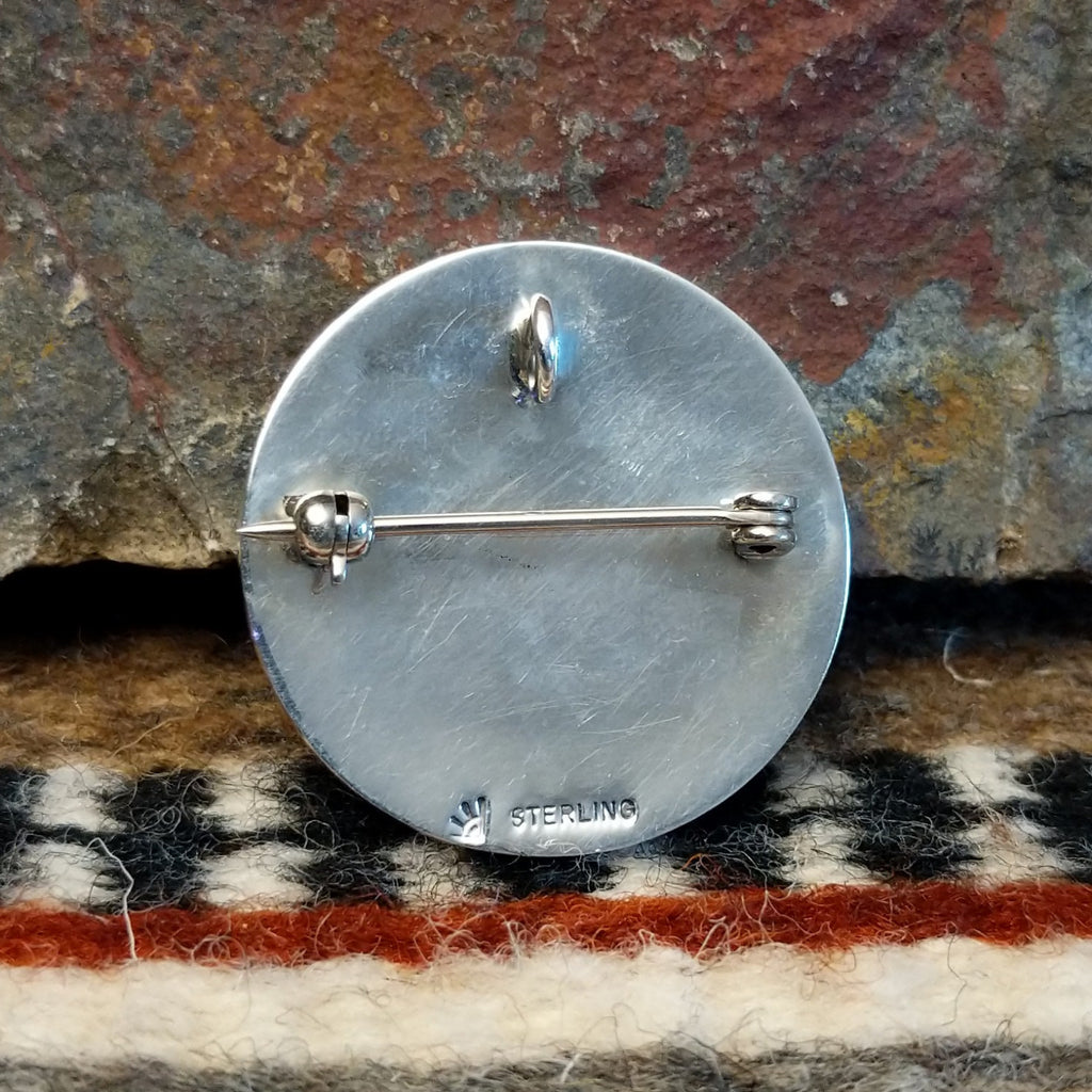 The back of the pendant features the artisan's hallmark.